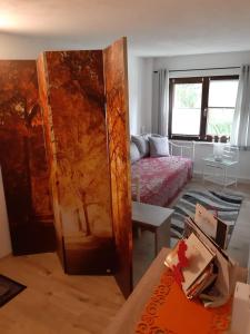 a living room with a bed and a wooden door at Familienfreundliche Ferienwohnung in Zschorlau