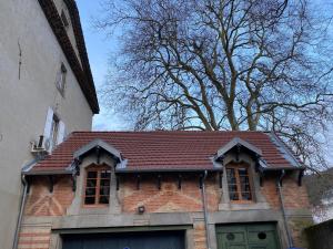 una casa de ladrillo con techo marrón junto a un edificio en Le Gite des Jardins de Mazamet, en Mazamet