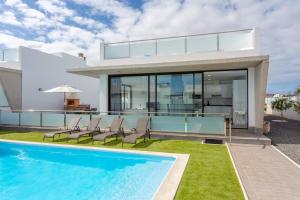 een villa met een zwembad en een huis bij Villas Mariposas Dreams in Corralejo