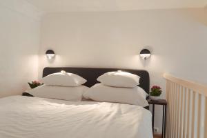 two pillows on a bed with two lights on the wall at Smile Apartments zur Gozzoburg in Krems an der Donau
