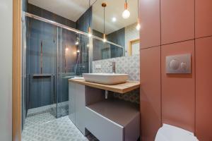 a bathroom with a sink and a shower at Apartamenty Sun & Snow Aura III in Gdańsk