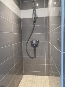 y baño con ducha y manguera. en Hotel du Commerce en Châtillon-sur-Chalaronne