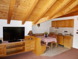 uma sala de estar com uma televisão grande e uma cozinha em Haus Central Oberstdorf em Oberstdorf