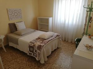 a bedroom with a bed and a window at LA COQUILLE appartamento vicino all'ospedale in Negrar