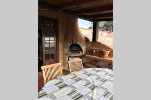 d'une terrasse avec une table et une cheminée. dans l'établissement Demi villa à 150m de la plage avec vue sur mer, à Appietto