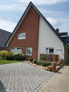 une maison avec une allée en briques devant elle dans l'établissement Hotel-Pension Achtern Diek, à Büsum