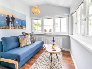 a living room with a blue couch and a table at OSTSEELOFT BINZ - Villa Amanda WG 08 in Binz