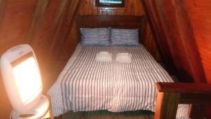 a small bed in a cabin with two pillows at Chalé - Sossego 1 in Campos do Jordão