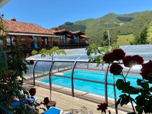 a resort with a swimming pool and mountains in the background at Casa Rural Alquitara in Ojedo