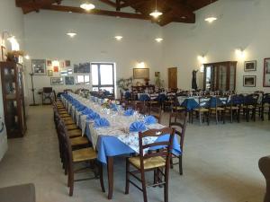 a large banquet hall with long tables and chairs at Palazzo Piccolo in Ascoli Satriano