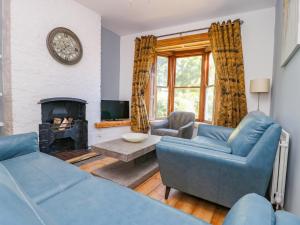 ein Wohnzimmer mit 2 blauen Sofas und einem Kamin in der Unterkunft Baggergate House in York