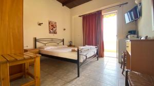 1 dormitorio con cama y ventana en Apanemia Rooms en Triopetra