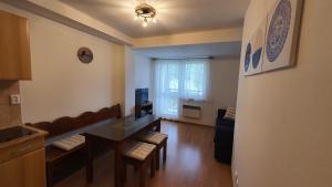 a living room with a table and chairs and a kitchen at Apartmán TATRAN Jarka in Donovaly +20 photos