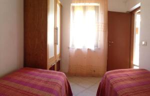 a bedroom with two beds and a window and a door at Il GIARDINO della FALENA in Favignana