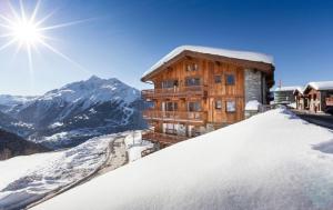 ein Holzgebäude auf einem schneebedeckten Berg in der Unterkunft Residence Miravidi La Rosiere in La Rosière