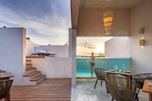a room with a table and chairs and a swimming pool at Kiki Tulum in Tulum