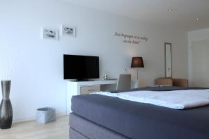 a bedroom with a bed and a flat screen tv at Lessing31 in Schotten