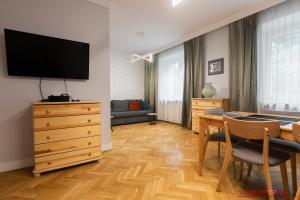 a living room with a dining room table and a television at Apartment Nearto Old Town Daszyńskiego street in Krakow