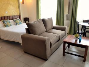 una sala de estar con un sofá y una cama en Kasty L Studios and Apartments, en Nairobi