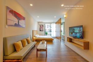 un soggiorno con un divano e una TV di Minimalist & Modern Apartment I a Phu Quoc