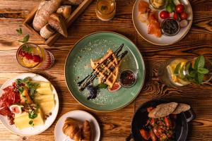 una mesa de madera con platos de comida. en The Bridge Suites, en Cracovia