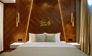 a bedroom with a large bed with a wooden headboard at Hotel Pupin Novi Sad in Novi Sad