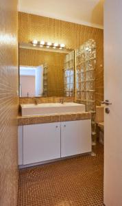 baño con lavabo y espejo grande en Timeless apartment at the heart of the village, en Ericeira