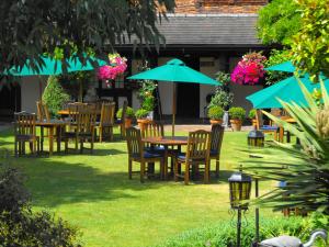 a group of tables and chairs with umbrellas at Marygreen Manor in Brentwood