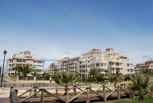 a row of apartment buildings with palm trees in front at Apartamentos Isla Canela y Punta del Moral in Isla Canela