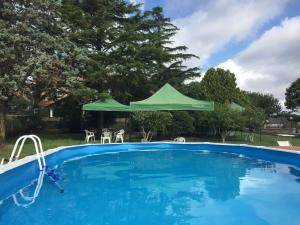 una piscina con ombrellone verde in un cortile di Le3sorelle a Monterosi