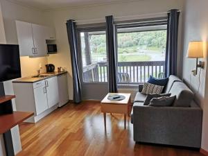 uma pequena sala de estar com um sofá e uma cozinha em Bjugn Hotell em Botngard