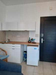 uma cozinha com um frigorífico branco e uma cadeira azul em Studio Apartman MIJA 1 em Malinska