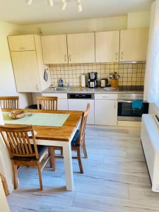 a kitchen with a wooden table and chairs in it at ''Zur alten Boddenfischerei'' Ferienwohnung Weitblick in Saal