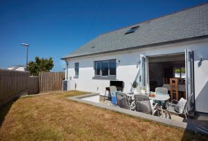 a white house with a patio with a table and chairs at Beacon View in St. Agnes 