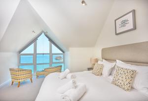 Un dormitorio con una cama con una ventana grande. en Westaway, en Portreath