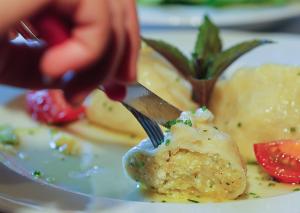 una persona comiendo comida en un plato con un tenedor en Gästehaus Watschinger, en Bad Wimsbach-Neydharting