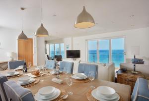 a dining room with a table and chairs and the ocean at Westaway in Portreath
