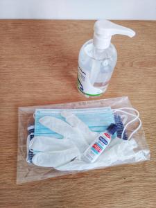 a plastic bag with a bottle of mouthwash and a pair of gloves at toStay-Unique apartment hotel in Athens center! in Athens