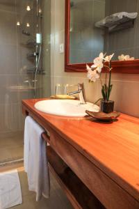 a bathroom sink with a vase of flowers on it at Mister Barracuda in Santa Maria