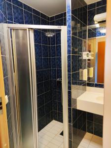 ein Bad mit einer Dusche und einem Waschbecken in der Unterkunft Hotell Erikslund in Ängelholm