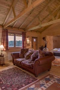 a living room with a brown couch in a room at Wranglers Den in Bilsthorpe