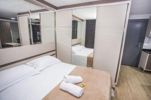 1 dormitorio con 2 camas y espejo en Studio com Cama e Sofá-Cama de Casal - ALL2011 en Curitiba