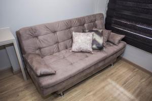 een bruine bank met kussens in een kamer bij Studio com Cama e Sofá-Cama de Casal - ALL2011 in Curitiba