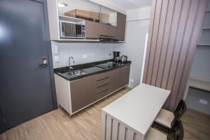 een keuken met een aanrecht, een wastafel en een tafel bij Studio com Cama e Sofá-Cama de Casal - ALL2011 in Curitiba