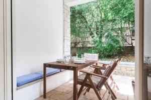 une table et des chaises sur une terrasse avec une fenêtre dans l'établissement Homz AH19 Psychiko Apartment, à Athènes