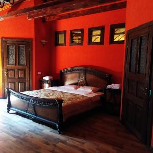1 dormitorio con 1 cama con pared de color naranja en Pan Otaman en Pisarevka