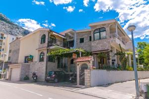 a house with a motorcycle parked in front of it at Villa Palma Apartments in Makarska