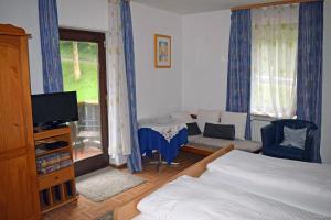 een slaapkamer met een bed en een tv en een bank bij Waldgasthof Altersbach in Waldkirch