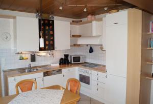 a kitchen with white cabinets and a table and a microwave at Ferienwohnung Am Sundern in Tecklenburg