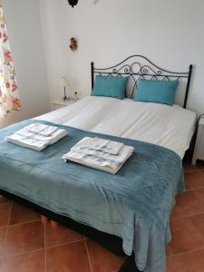 Una cama con dos toallas encima. en Casa Ayo en Frigiliana